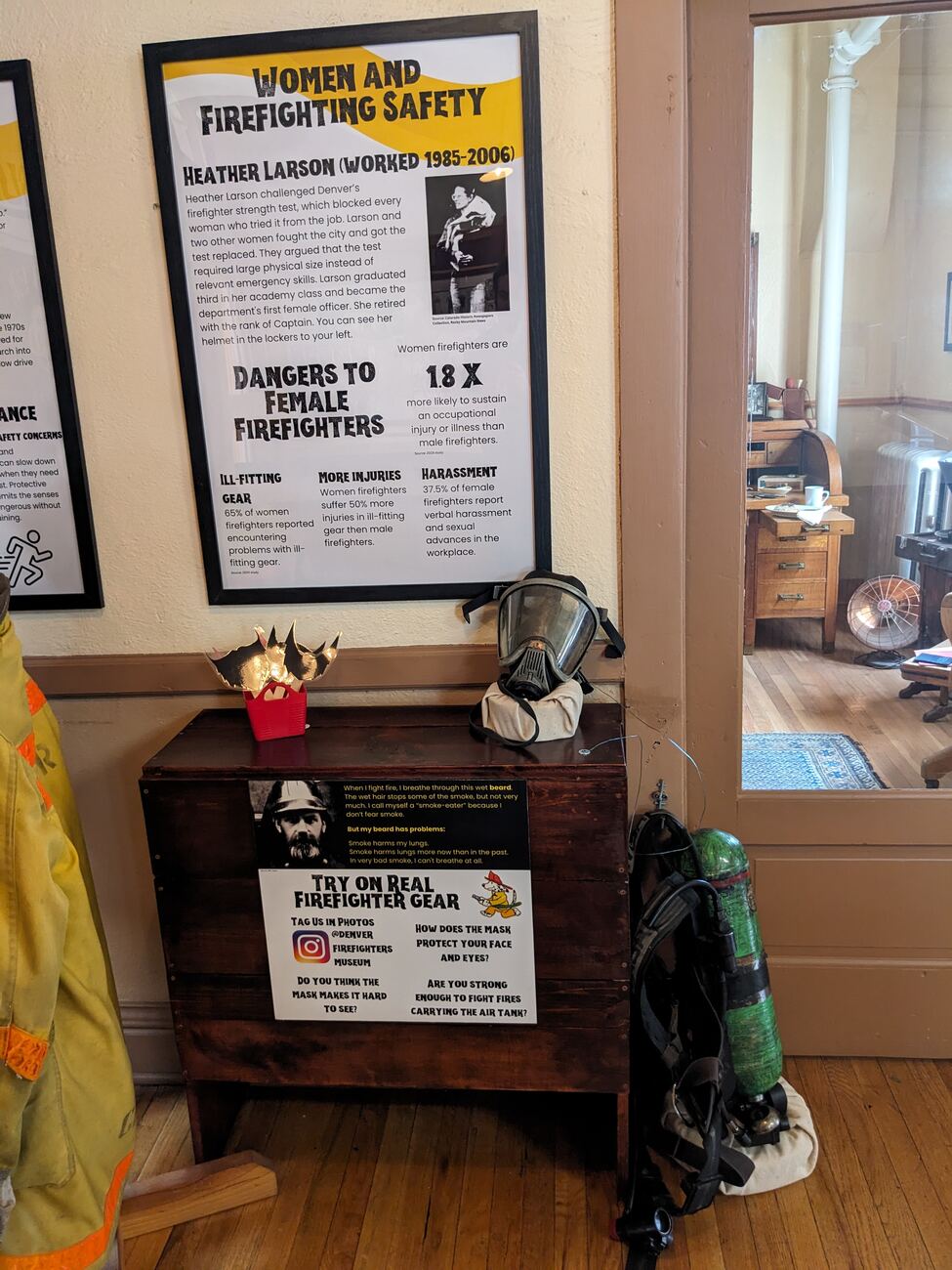 Mask try-on station: a modern SCBA mask and air tank beside historic beard-filter imagery, with an Instagram tag-us callout and the Women and Firefighting Safety panel behind.